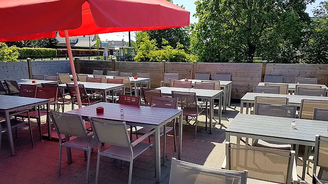Het terras van Frituur 't Liefken met parasol en tafels in de zon